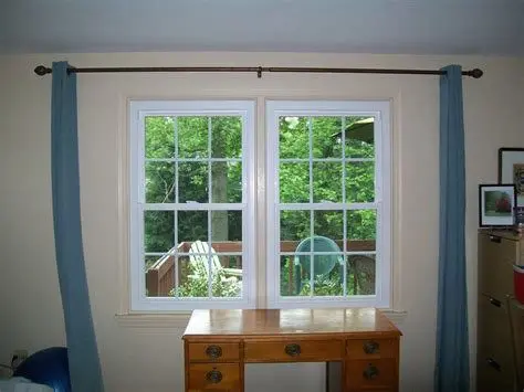 A desk with two windows and a chair in the background.